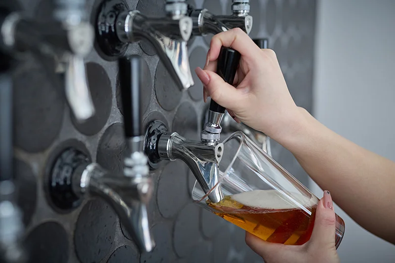 タップからグラスにビールを注ぐ